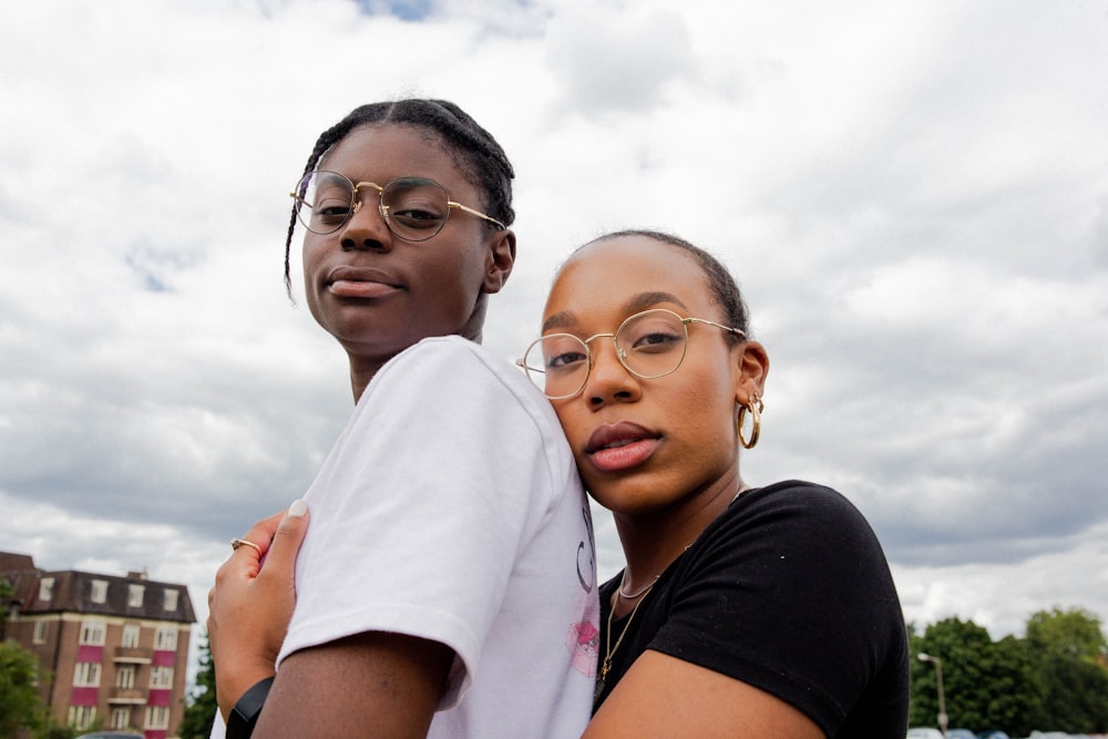 woman in white polo shirt beside woman in black shirt