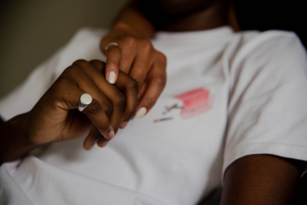 person with silver ring holding hands