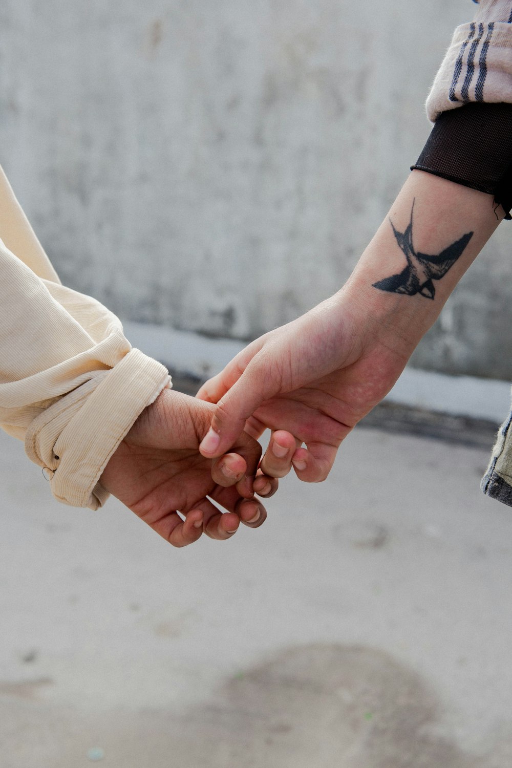 woman in black long sleeve shirt holding hands with woman in beige shirt