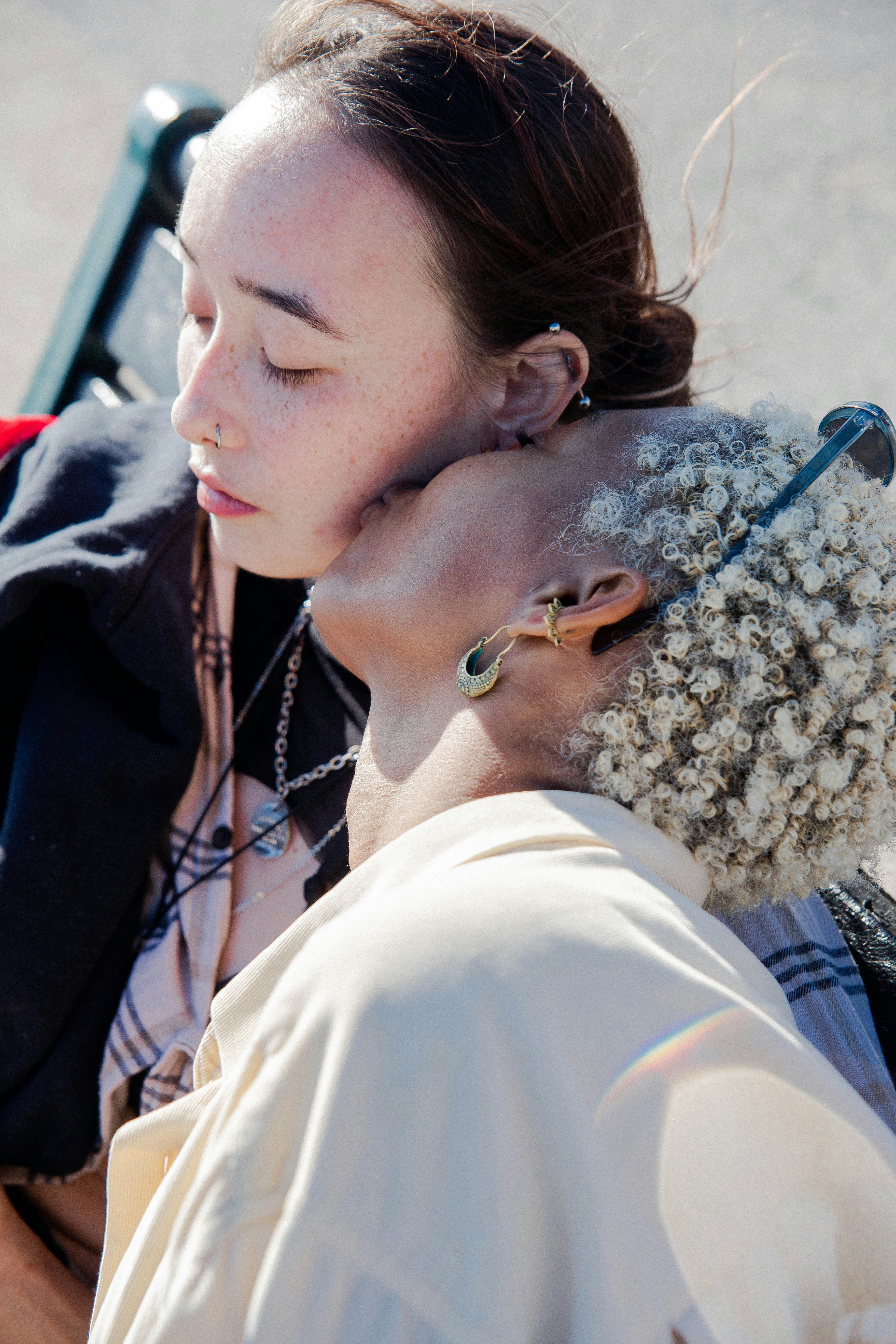 woman in white shirt kissing woman in black shirt