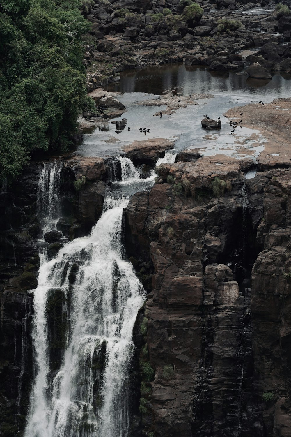 waterfalls on brown rocky mountain during daytime