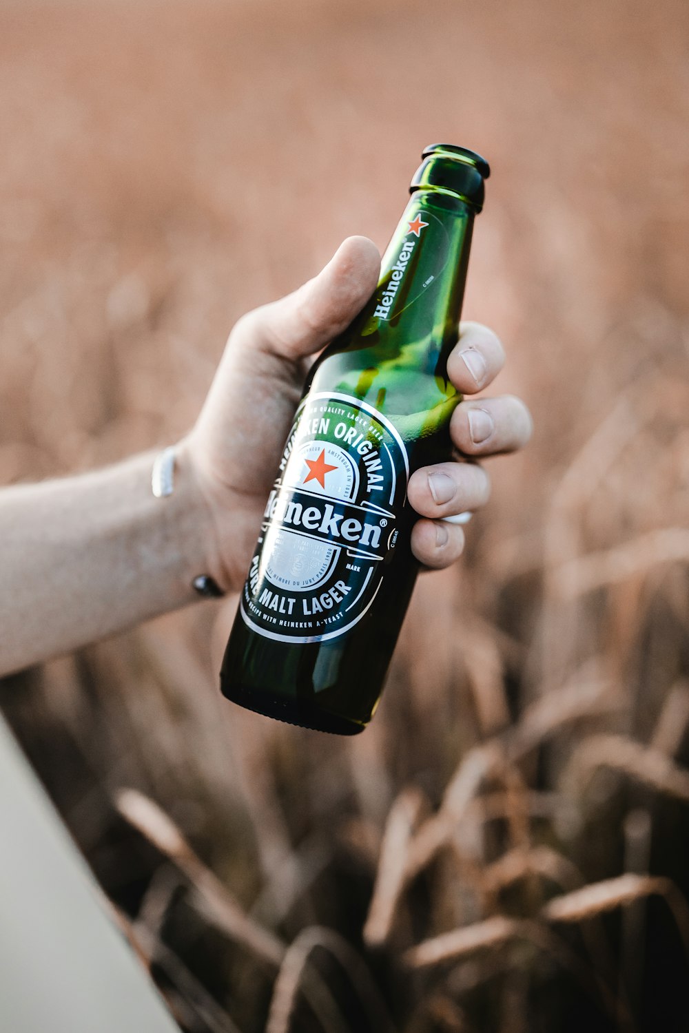 Person mit grüner Glasflasche