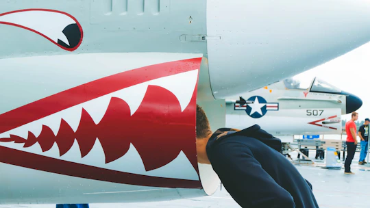 Technician inspecting aircraft ventilation system with specialized equipment.