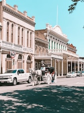A luxurious electric carriage touring a historic downtown area.