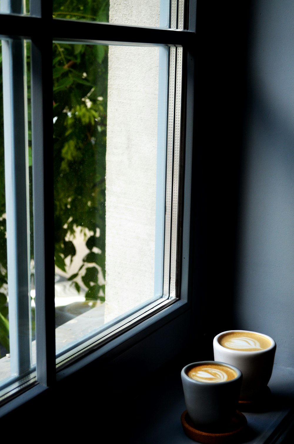 white ceramic mug on window