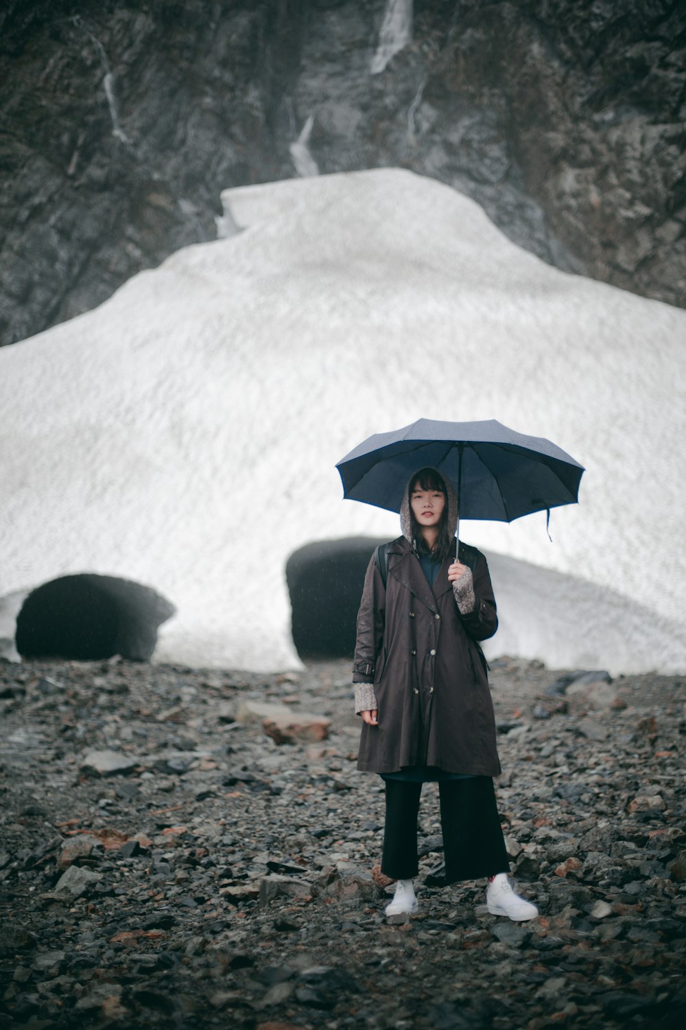 woman in black coat holding umbrella