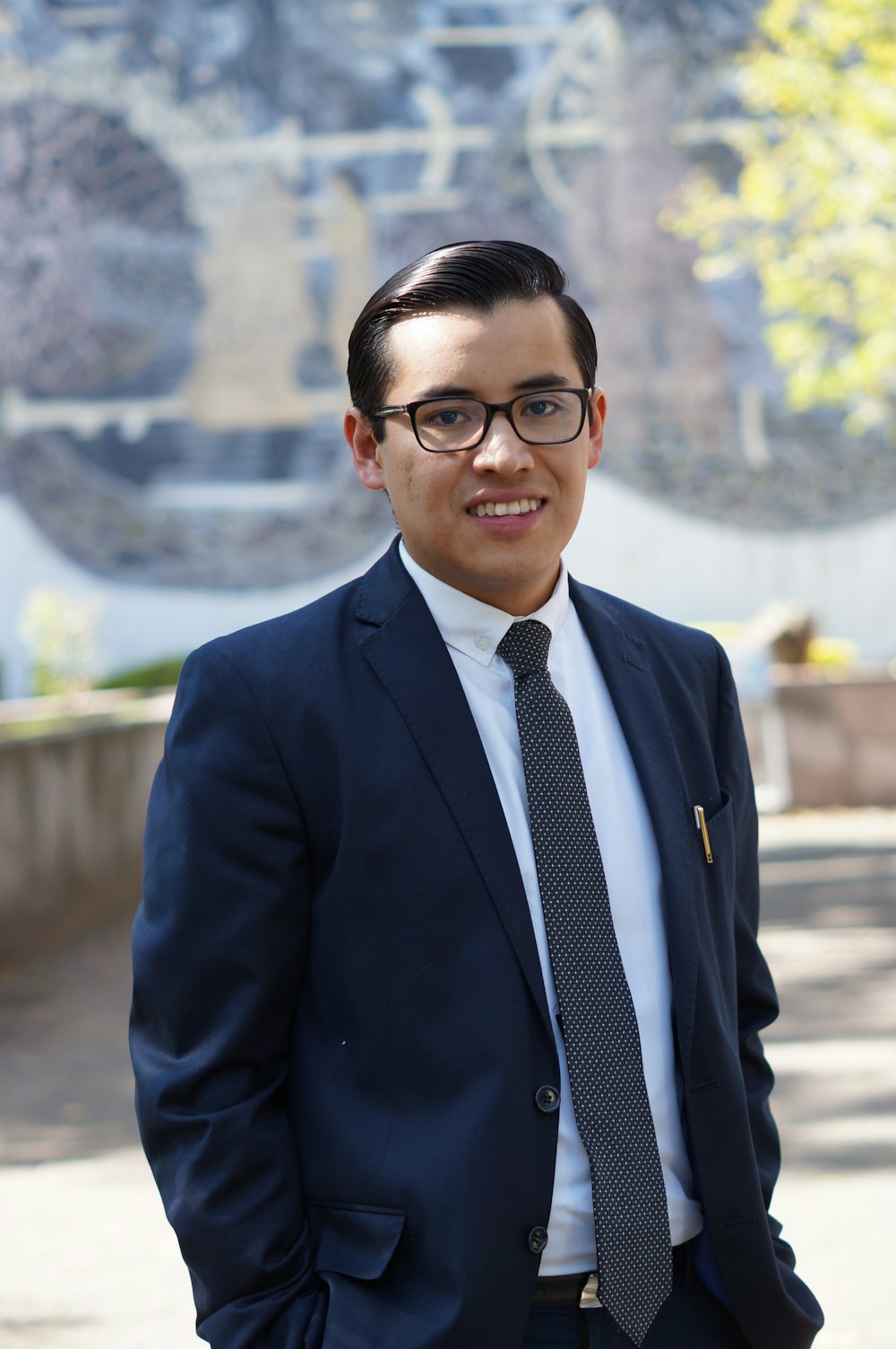 man in blue suit jacket wearing black framed eyeglasses