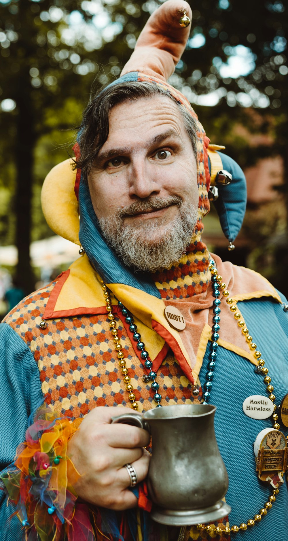 Hombre con camisa abotonada a cuadros naranjas y blancos con sombrero azul y amarillo