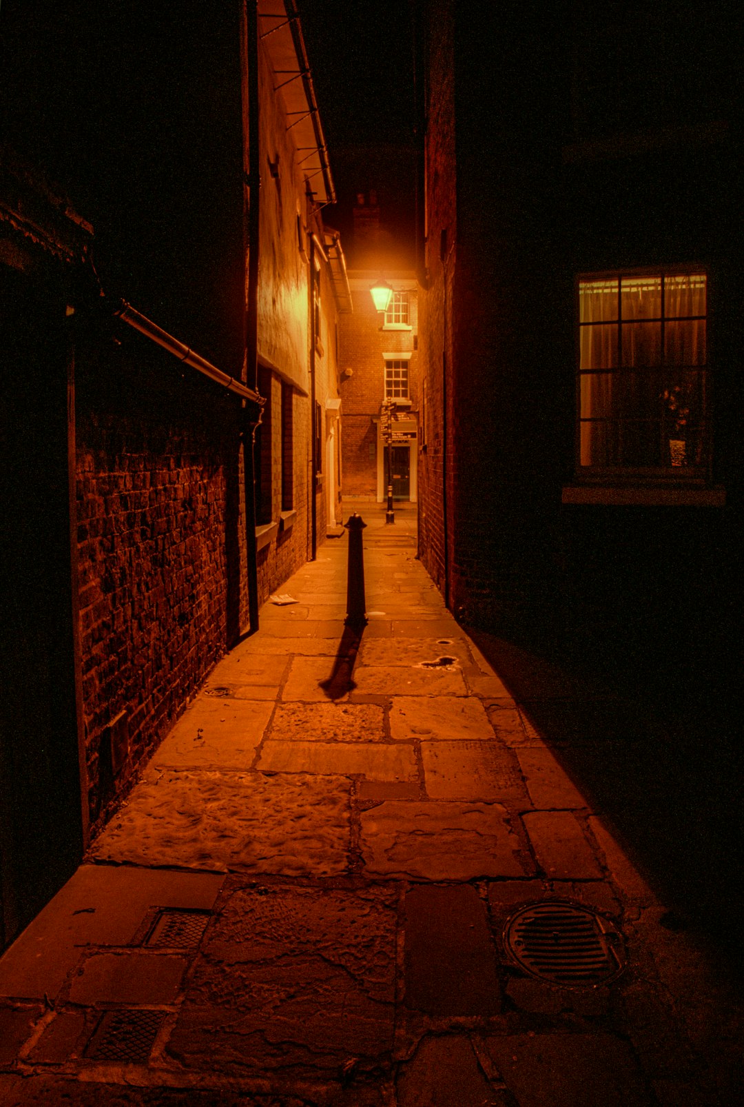 silhouette of person walking on sidewalk during night time