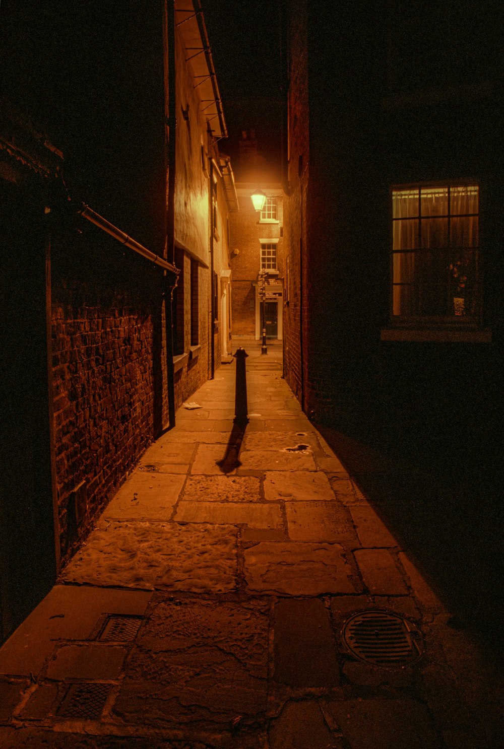 silhouette of person walking on sidewalk during night time