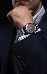 person wearing silver link bracelet round analog watch