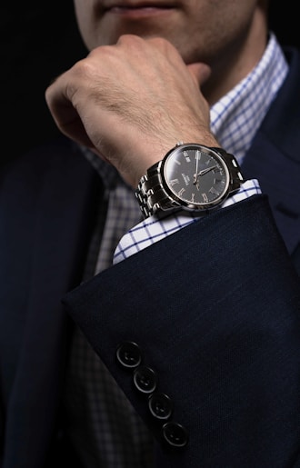 person wearing silver link bracelet round analog watch