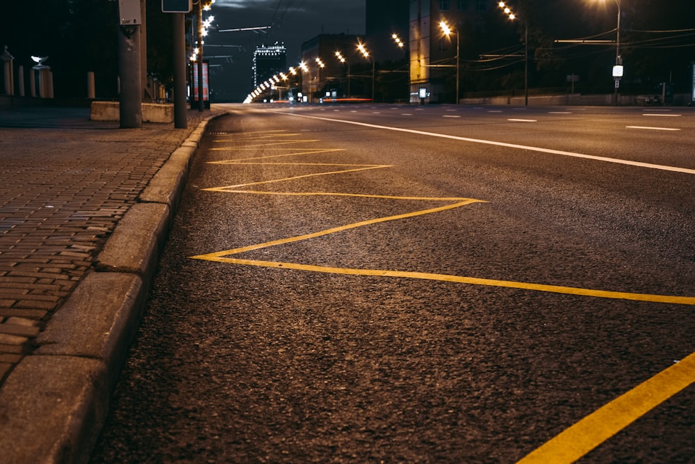 yellow line on gray asphalt road during night time