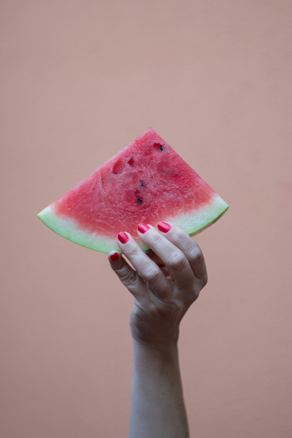 person holding sliced watermelon fruit