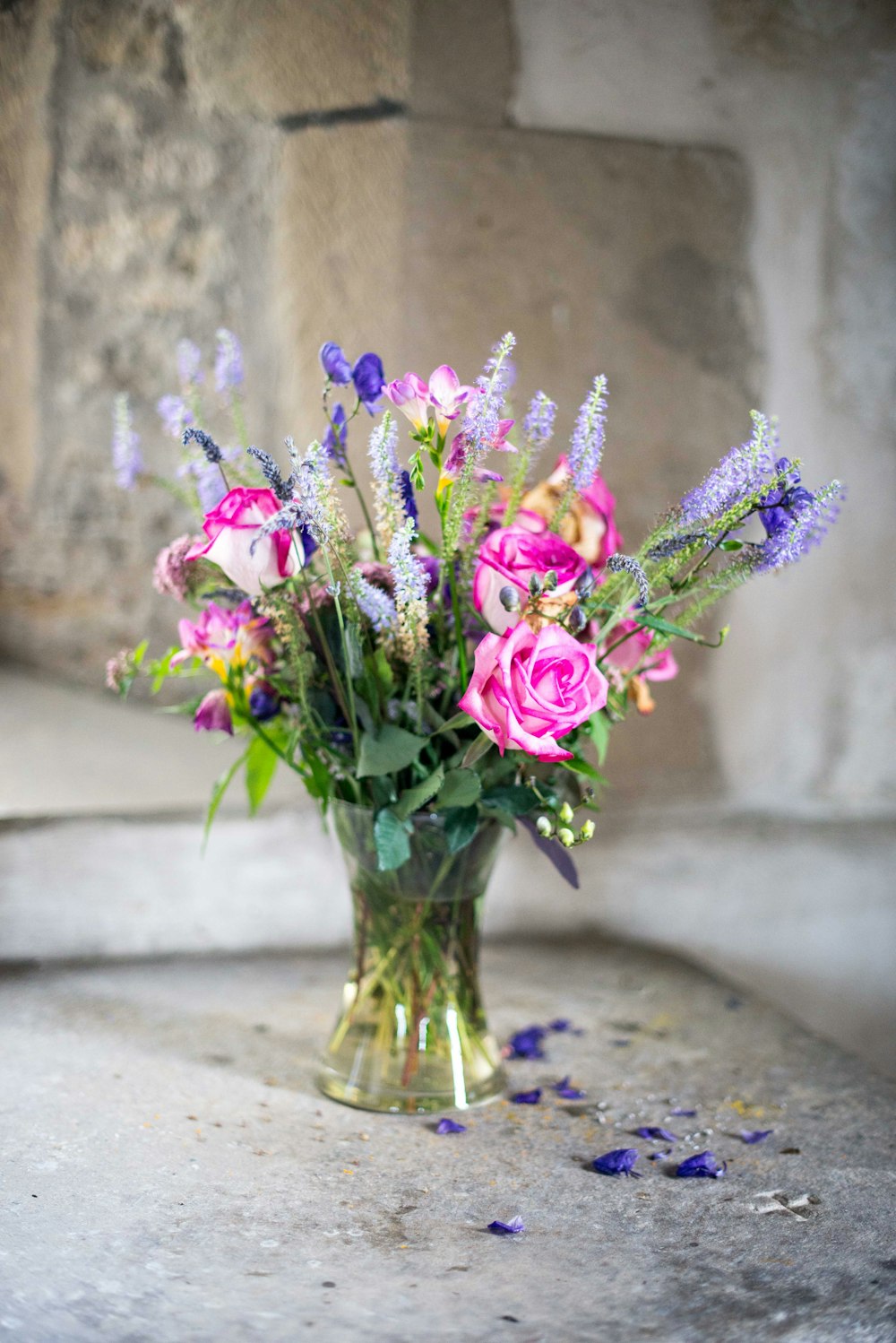 purple flowers in clear glass vase