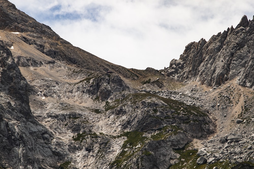 Montaña rocosa gris y marrón bajo cielo nublado blanco durante el día