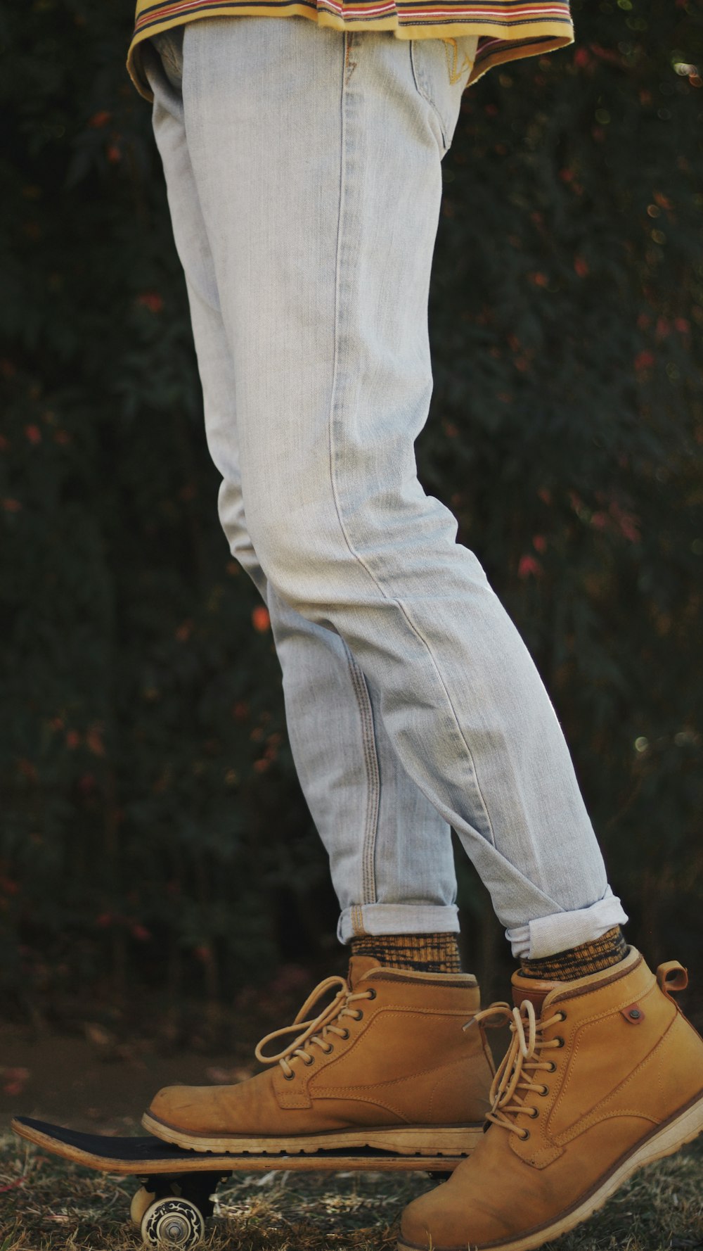 person in blue denim jeans and brown boots