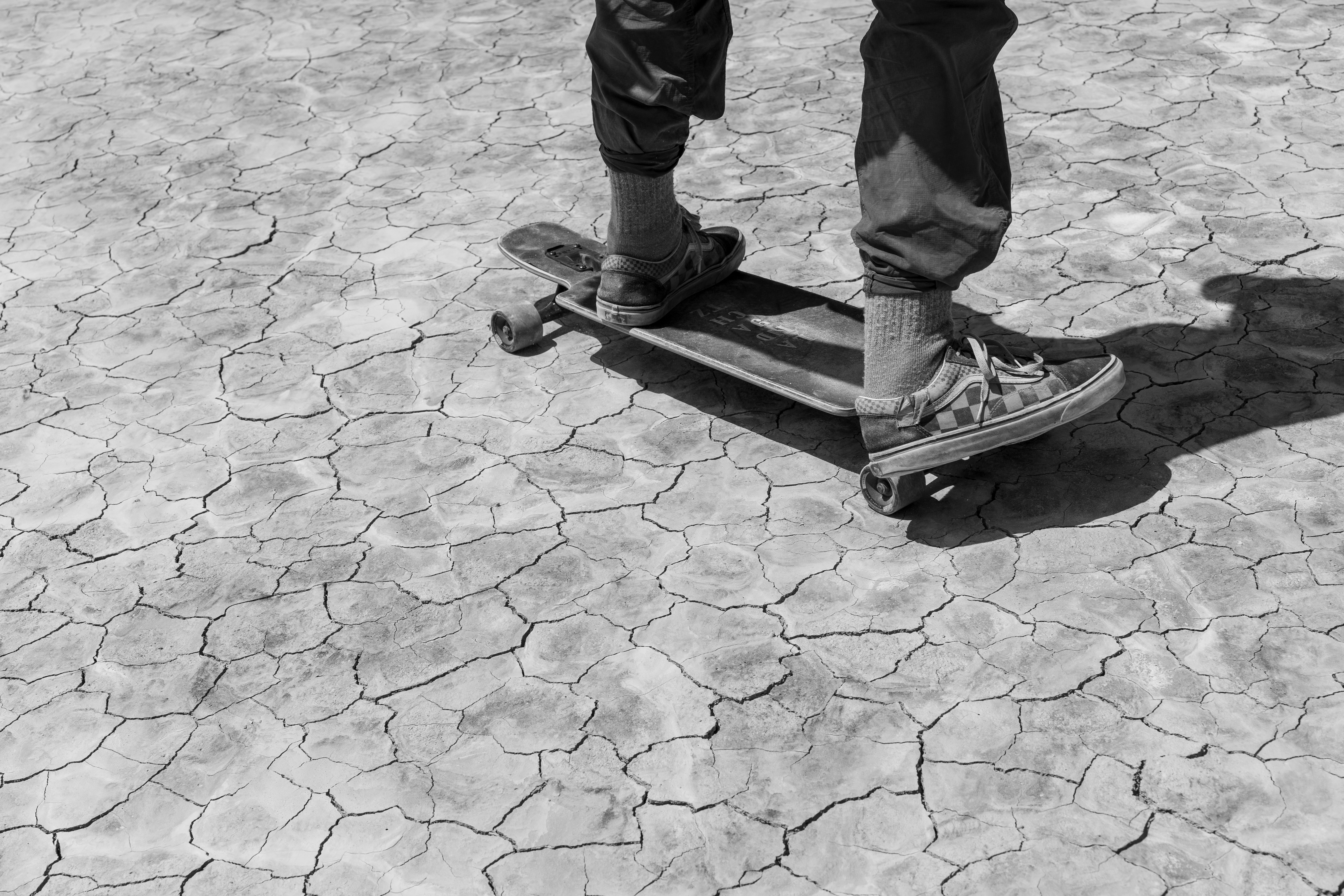grayscale photo of 2 children standing on concrete floor