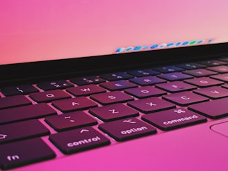 Close-up of hands typing on a laptop keyboard with bright, cheerful colors in the background.