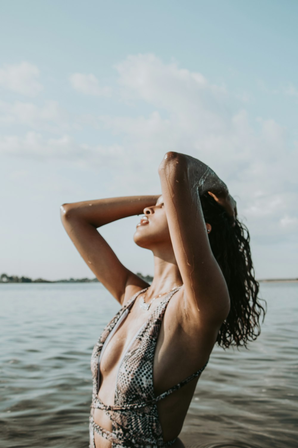 woman in white and black floral bikini top standing on sea shore during daytime