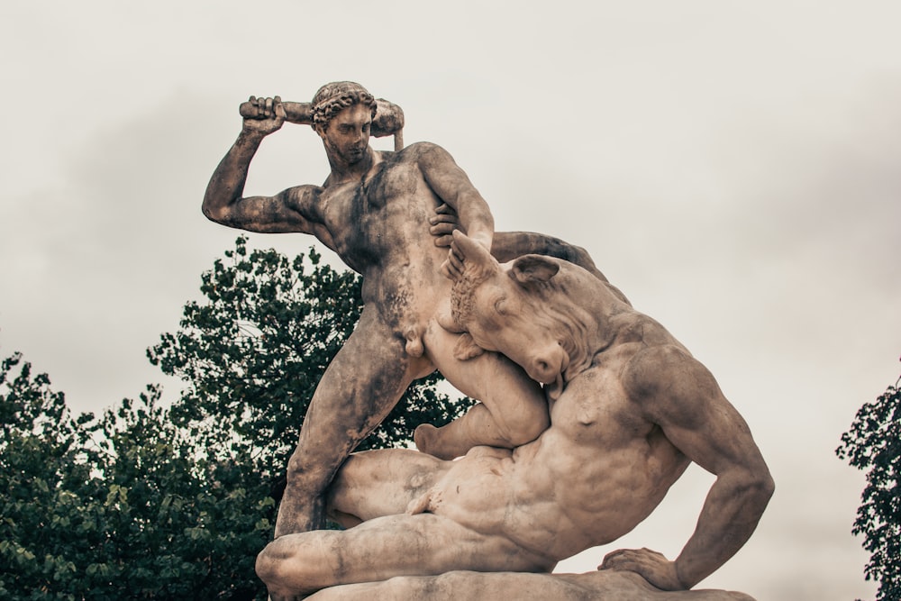 man statue under white sky during daytime