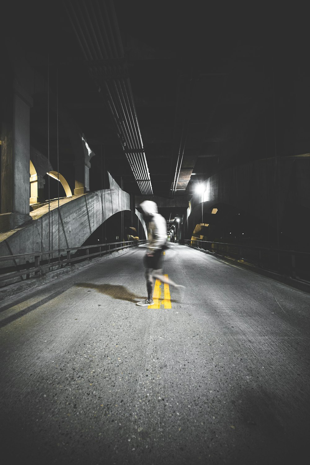 man in black jacket and yellow pants walking on sidewalk during night time