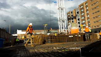 Construction workers wearing safety gear working on a clean, modern building site.
