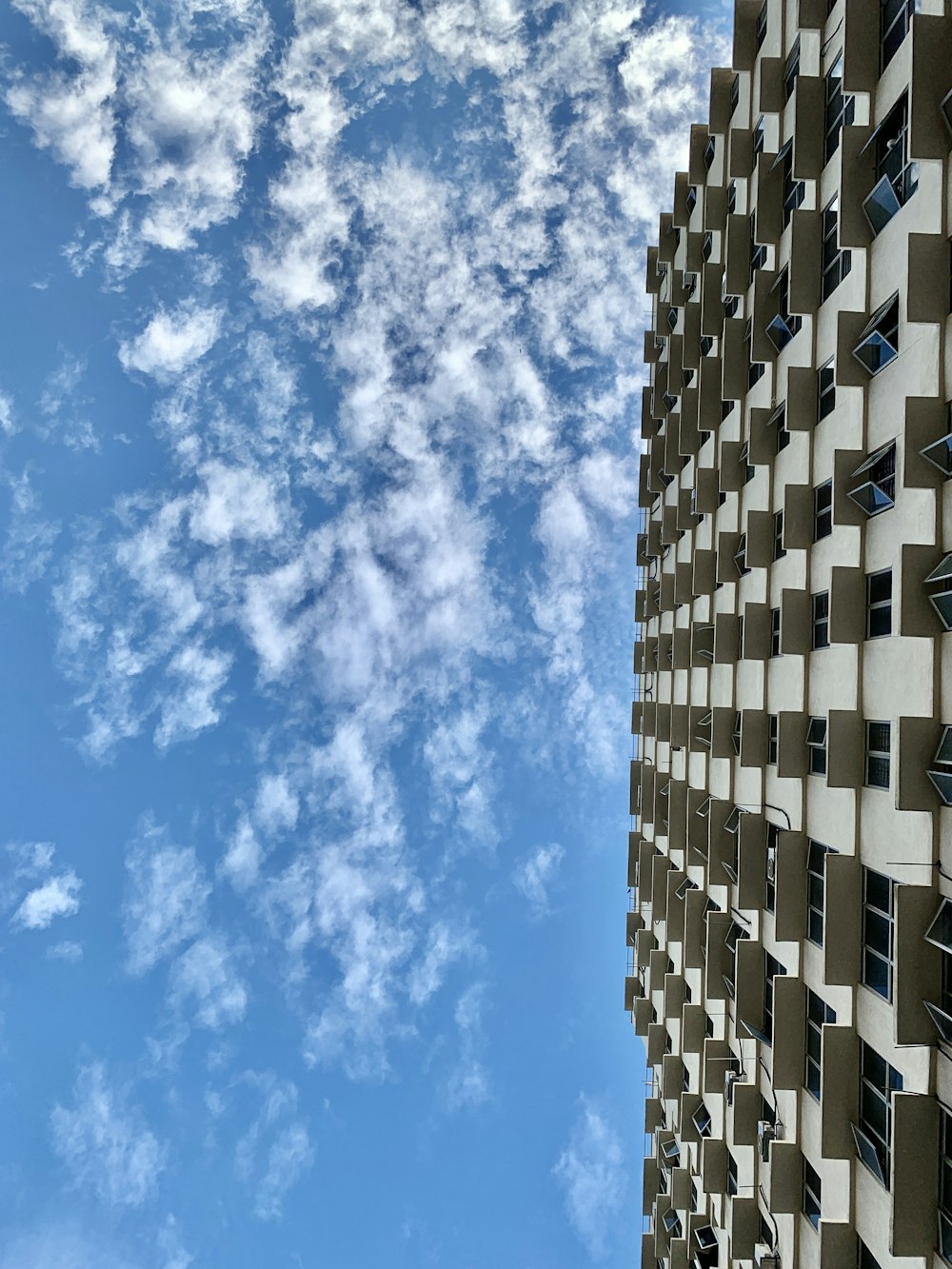 bâtiment en béton blanc et bleu sous le ciel bleu pendant la journée