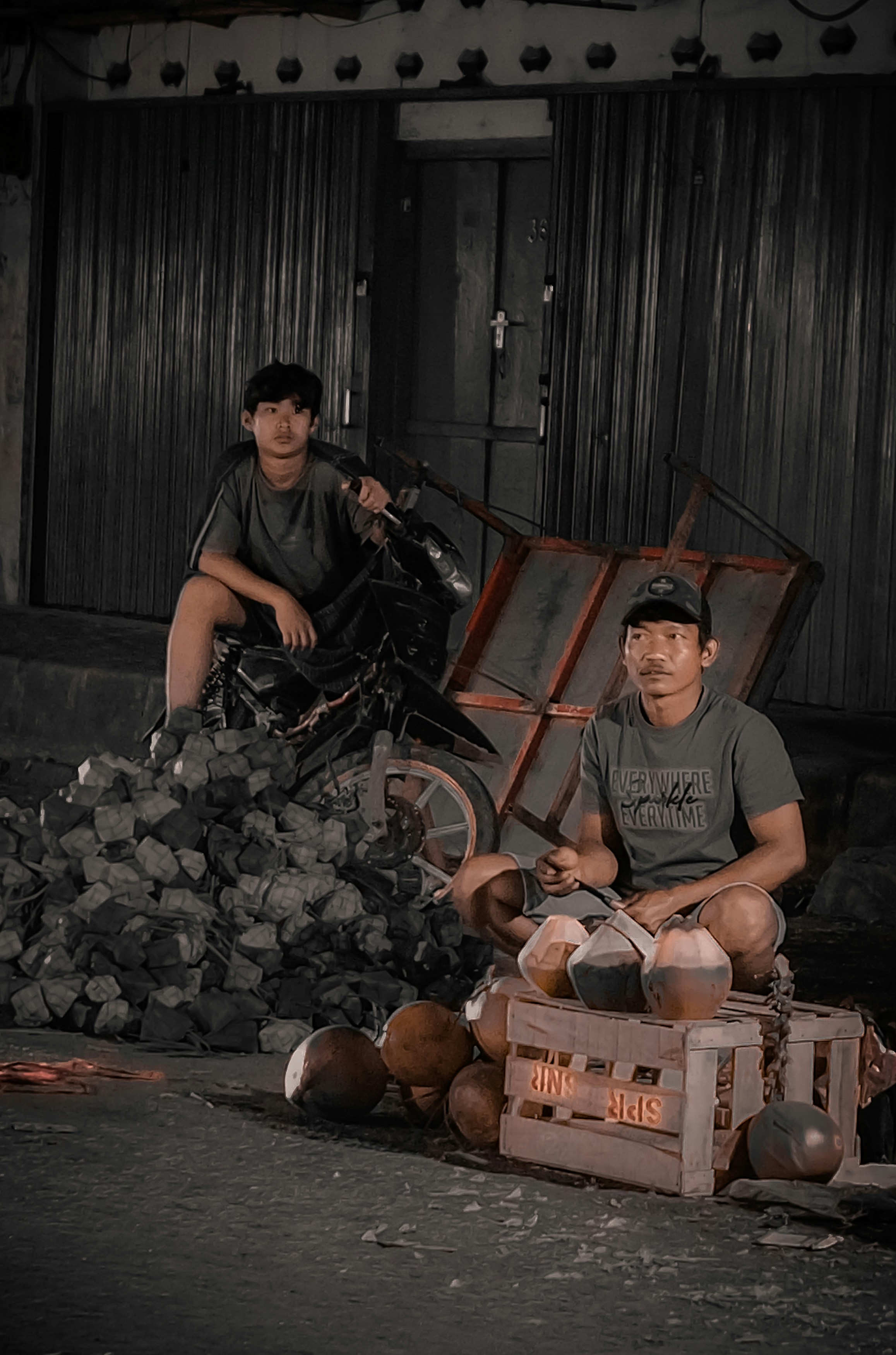 Pria berkaos leher kru abu-abu duduk di bangku kayu coklat