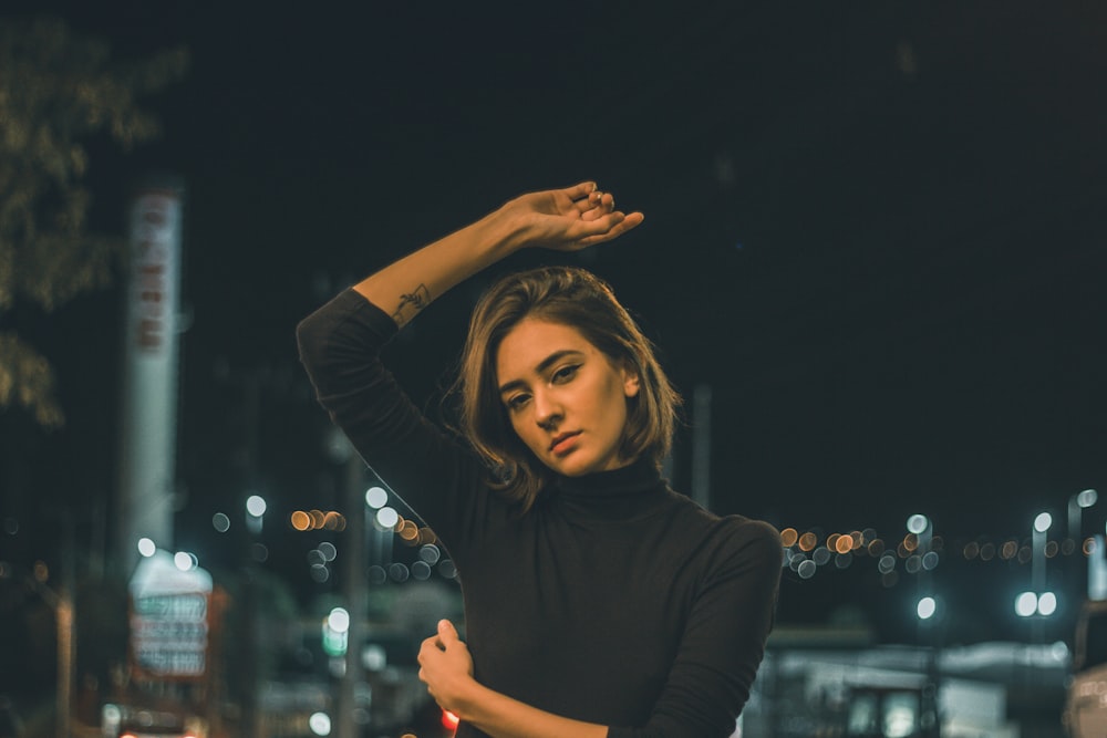 woman in black long sleeve shirt raising her hands