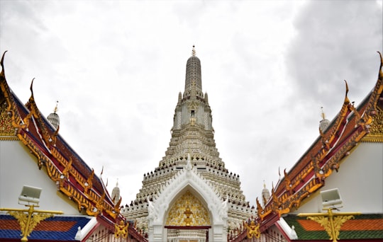 gold and white concrete building under white clouds during daytime in Wat Arun Ratchawararam Ratchawaramahawihan Thailand
