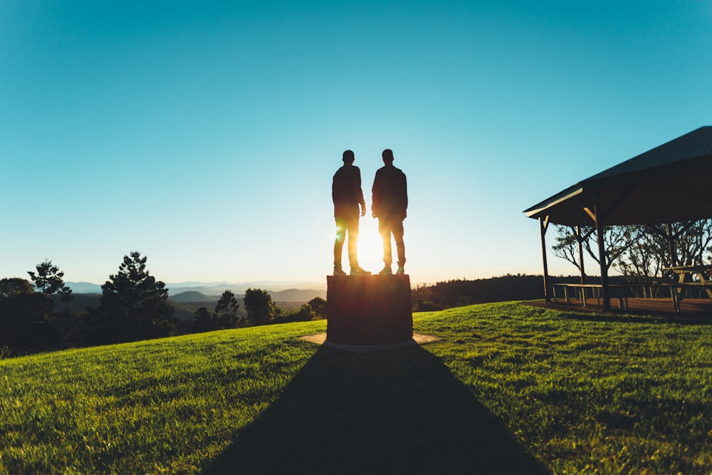 2 person standing on green grass field during daytime