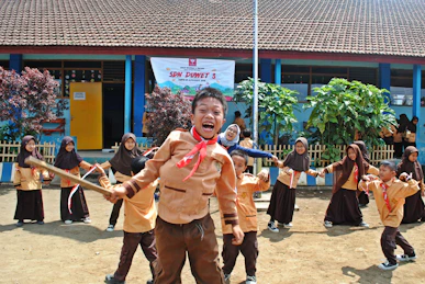girl in pink jacket standing on brown sand during daytime