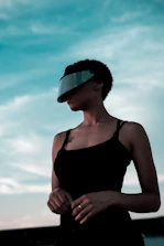 woman in black spaghetti strap top wearing black sunglasses
