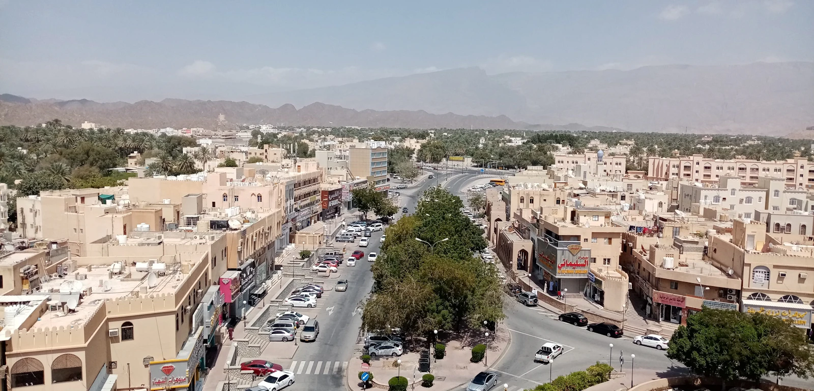 Cars parked below the walls of Nizwa Fort