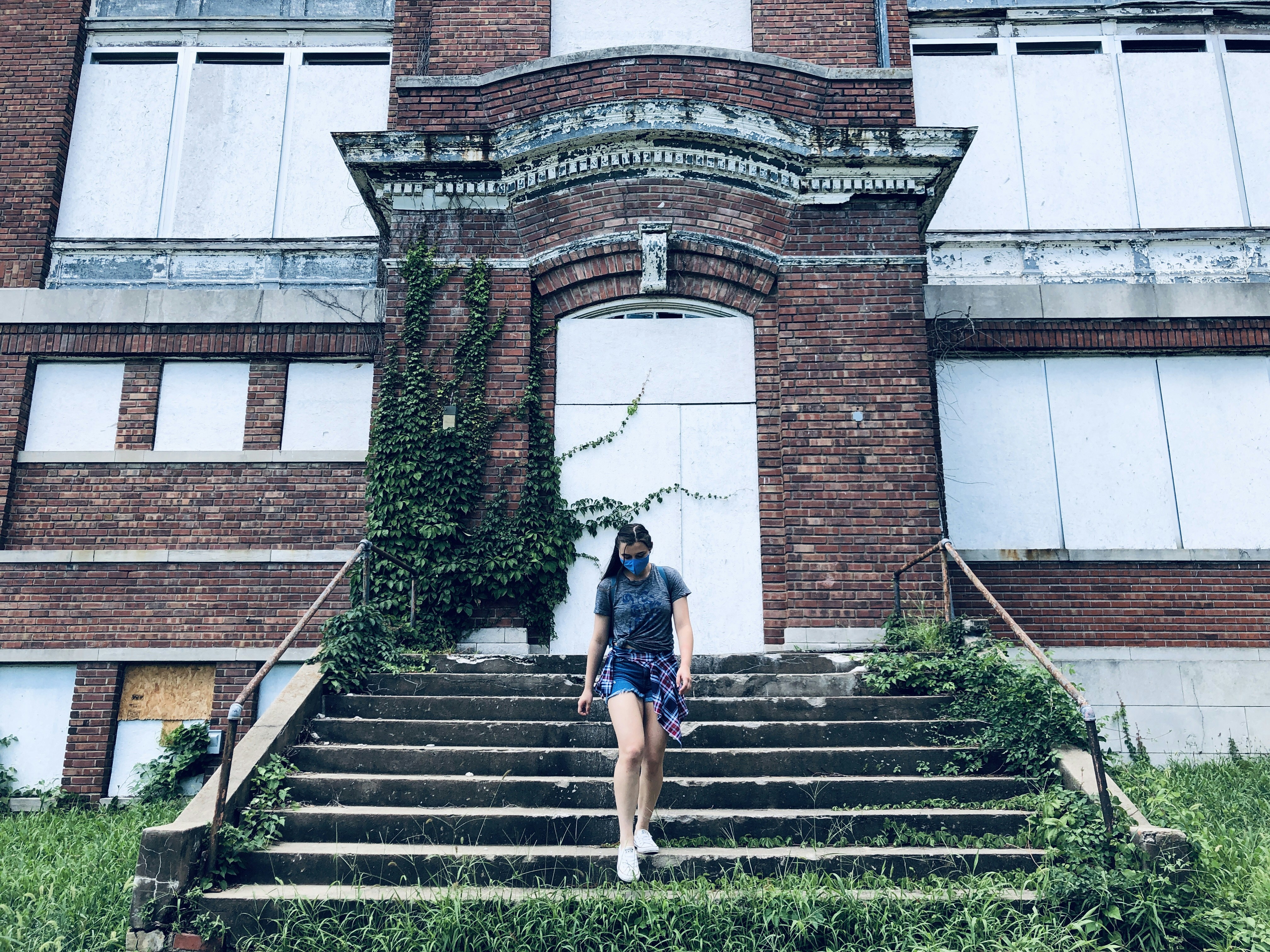 woman in black shirt and blue denim shorts standing on stairs