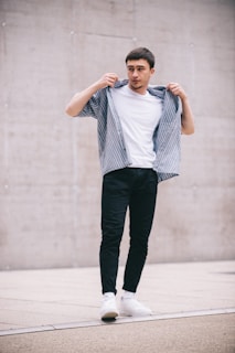 A young man confidently posing in fashionable streetwear.
