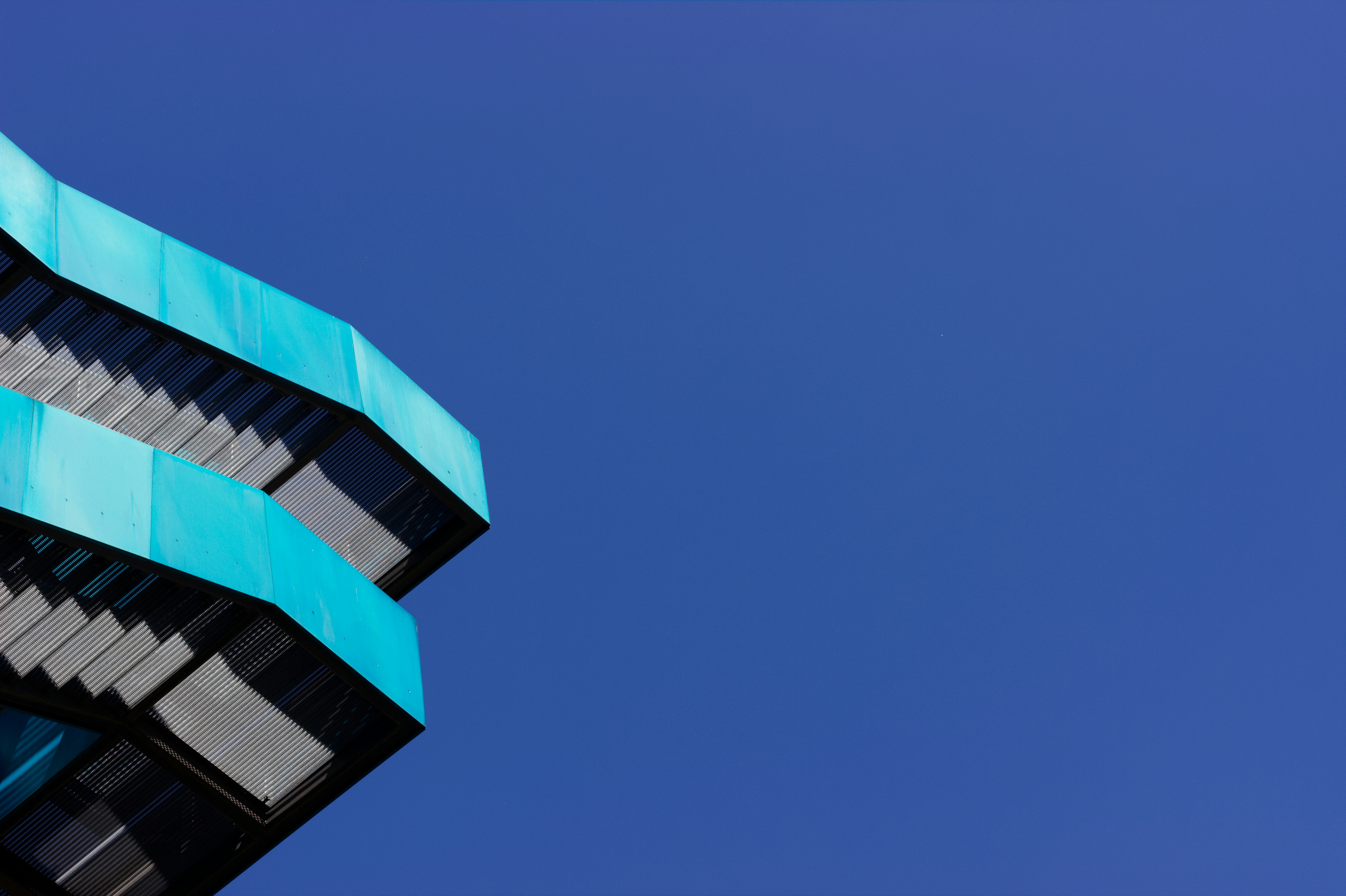 a tall building with a blue roof against a blue sky