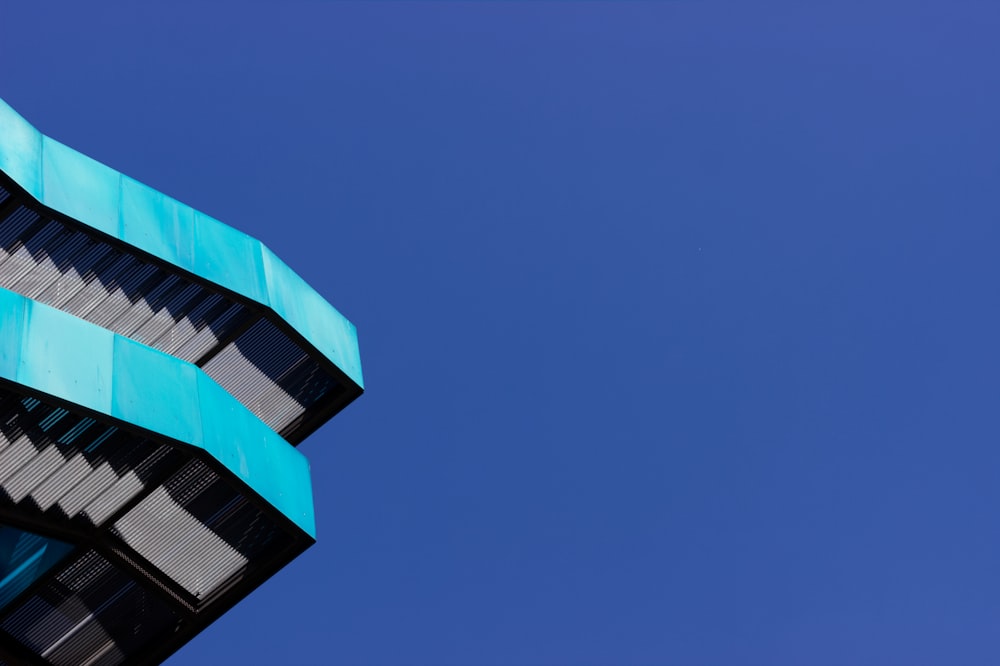 a tall building with a blue roof against a blue sky