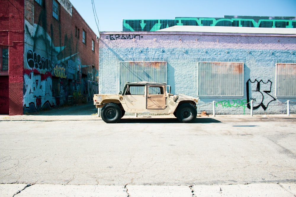 beige car parked beside concrete building during daytime