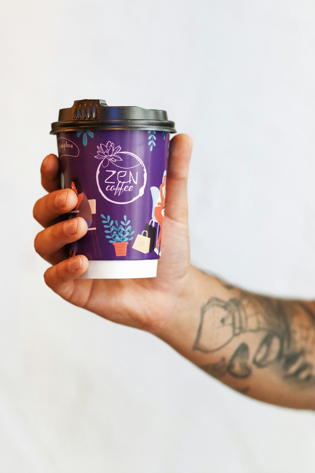 person holding blue and white disposable cup