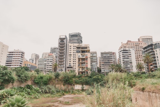 white concrete building near green trees during daytime in Beirut Lebanon