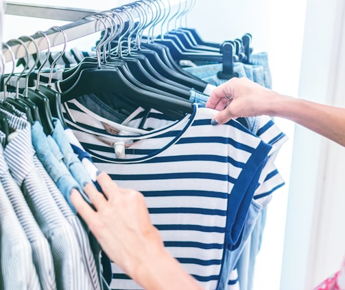 person holding white and black striped shirt