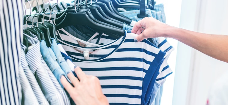 person holding white and black striped shirt