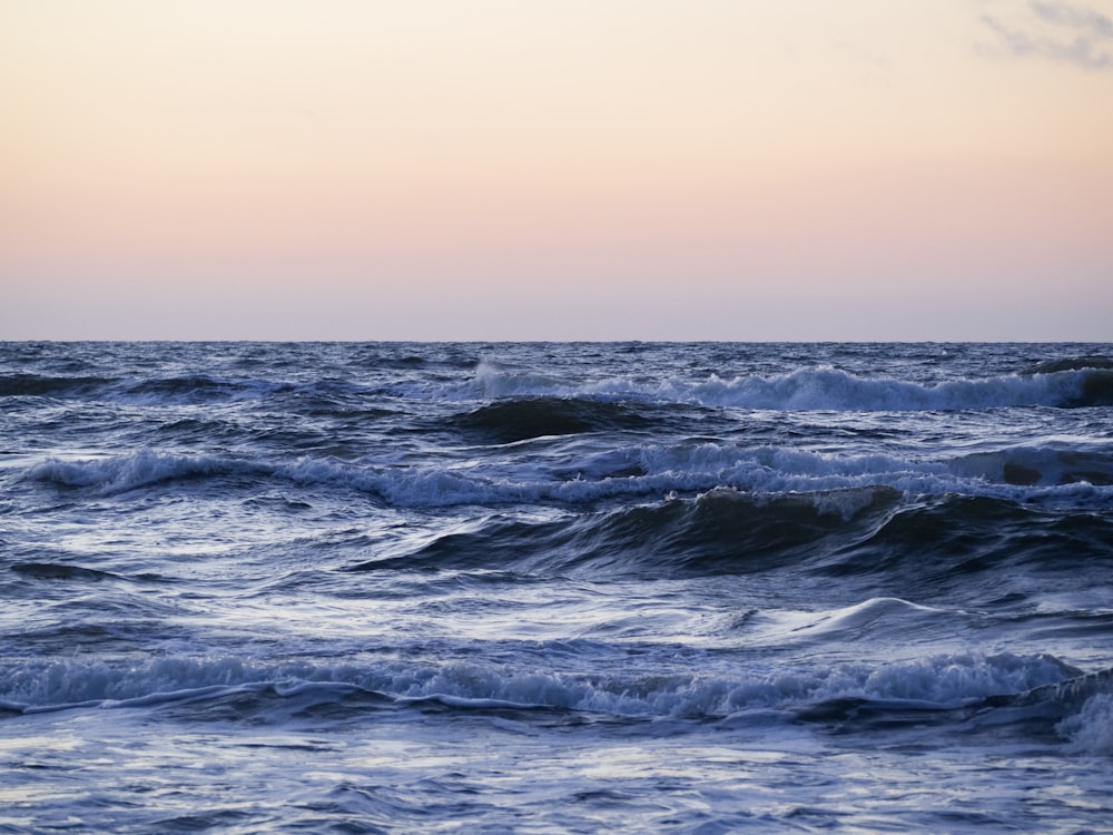 ocean waves under gray sky during daytime