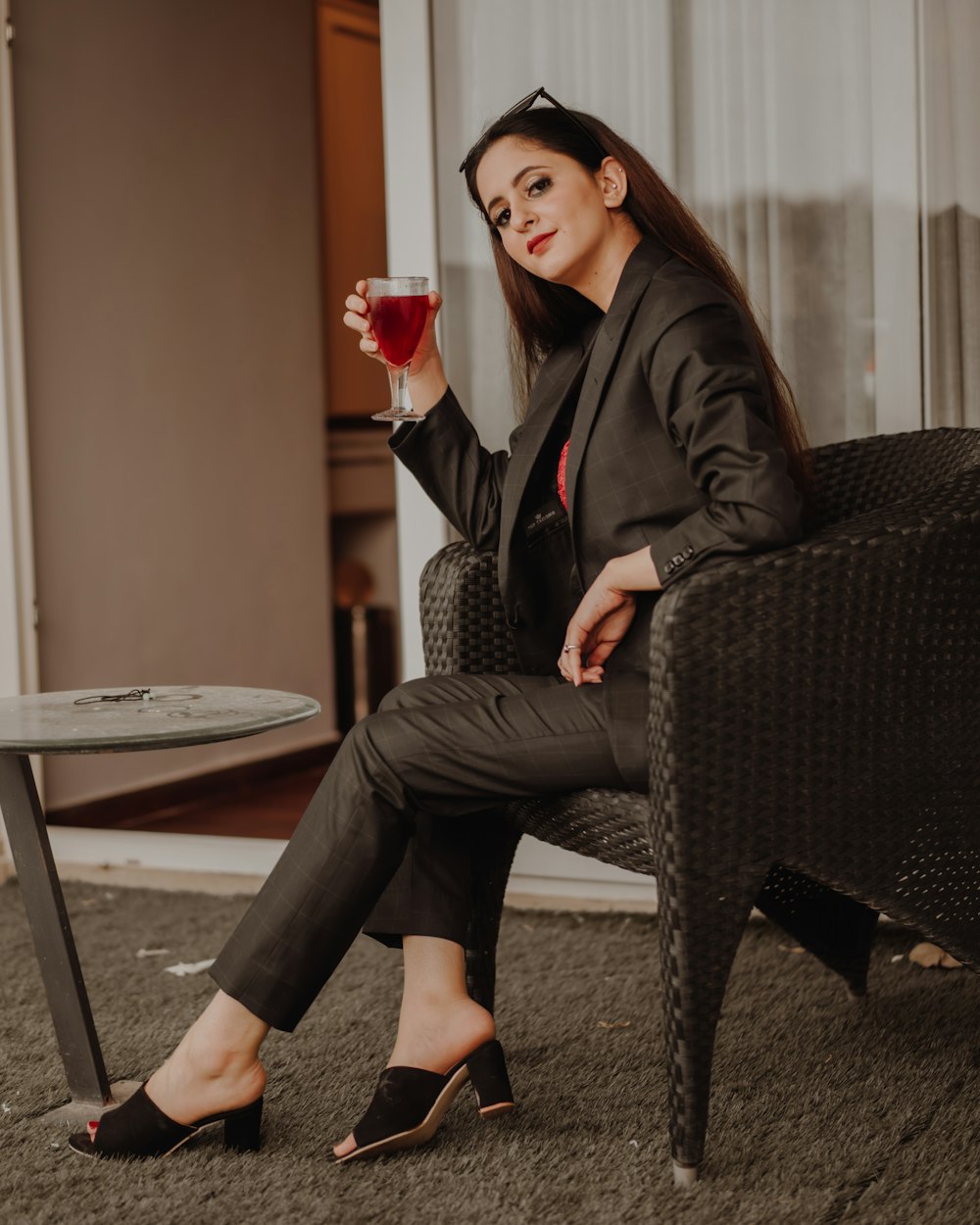 woman in black coat sitting on black and white chair