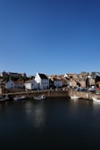 Crail, Fife andwhite and brown concrete buildings beside body of water under blue sky during daytime