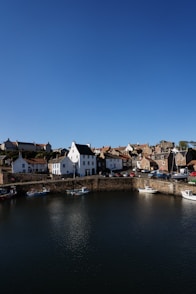 white and brown concrete buildings beside body of water under blue sky during daytime