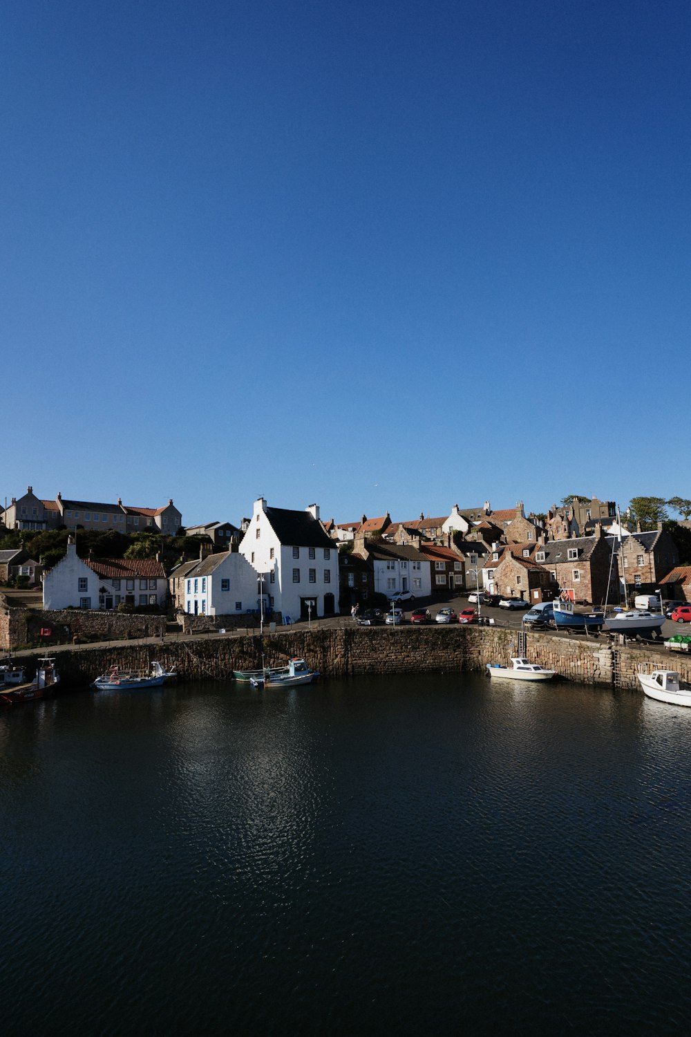 white and brown concrete buildings beside body of water under blue sky during daytime