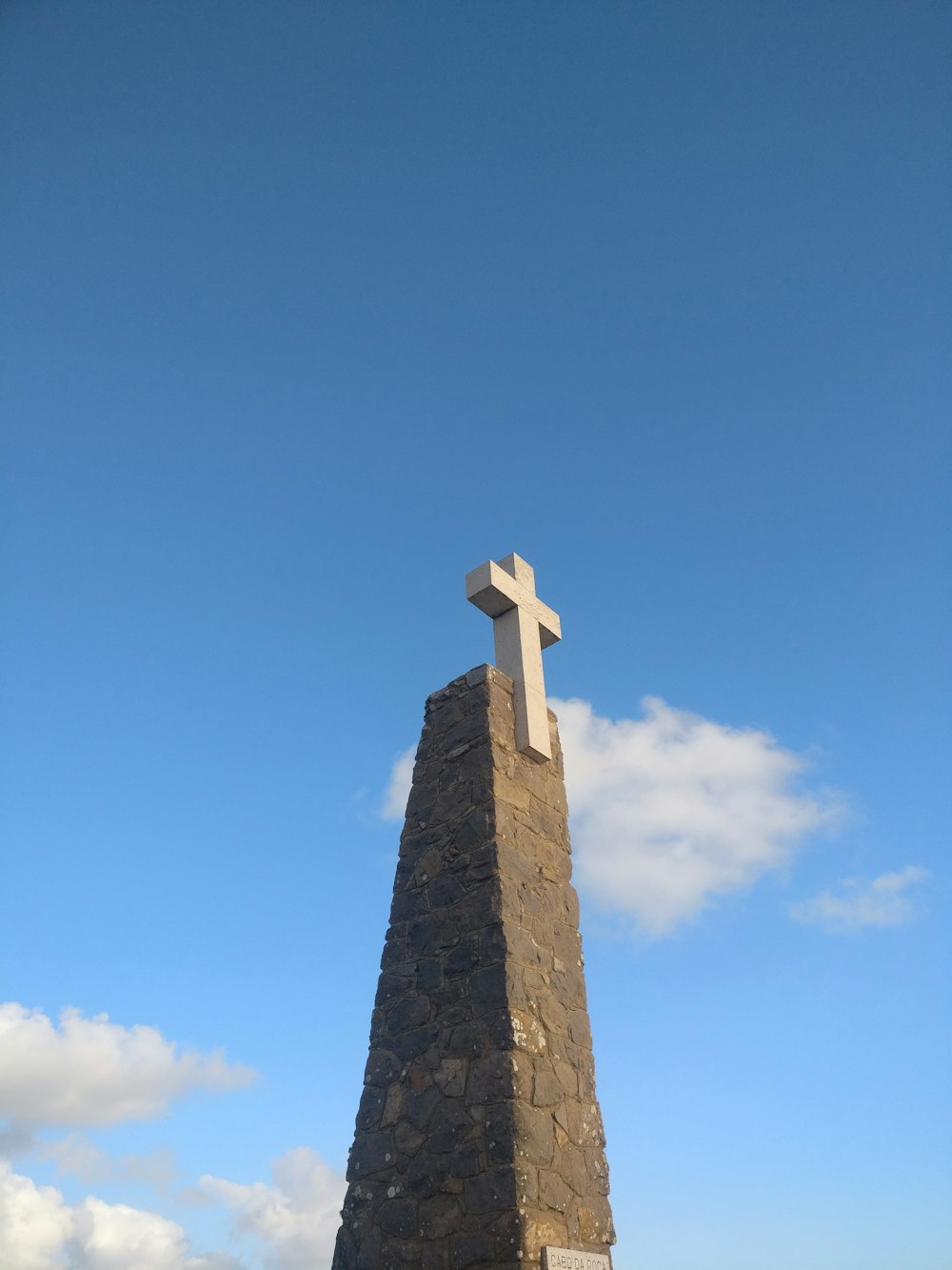 gray concrete cross under blue sky during daytime